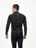 Man in zwart fietsjack en fietsbroek, van achteren gezien.