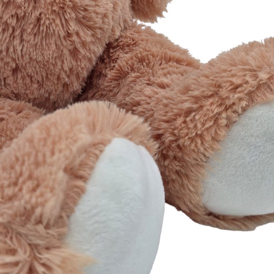 Gedeeltelijk zicht op de witte voetzolen van een bruine teddybeer.