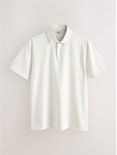Een crème poloshirt met korte mouwen en een knoopsluiting. Het shirt heeft een standaard pasvorm en is gemaakt van jersey.
