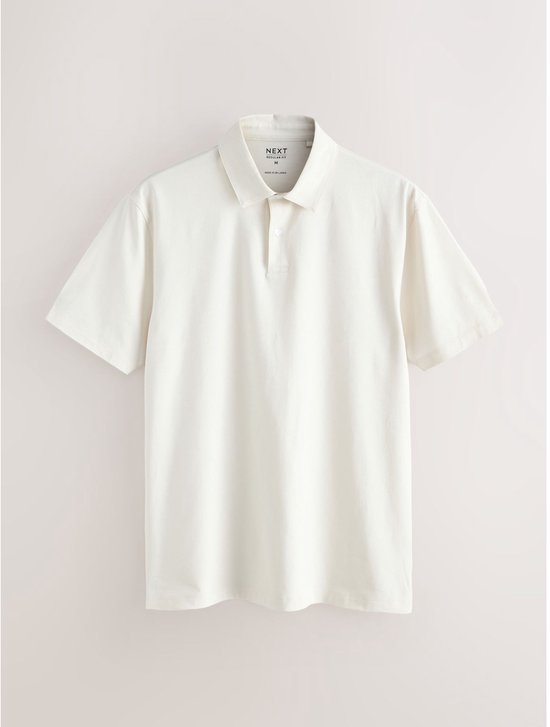Een crème poloshirt met korte mouwen en een knoopsluiting. Het shirt heeft een standaard pasvorm en is gemaakt van jersey.