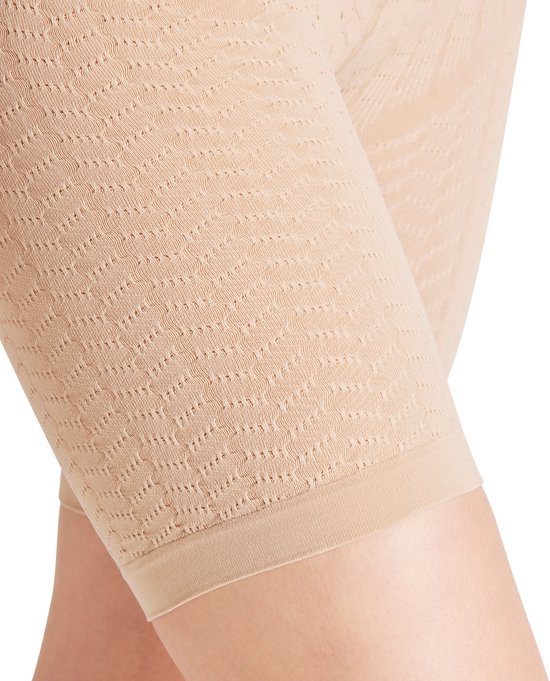 Close-up van een huidkleurige dames short met een golvend, perforerend patroon op de bovenbenen.