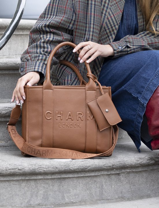 Bruine tote bag met 'CHARM LONDON' in reliëf, draagbanden en bijpassend etui.