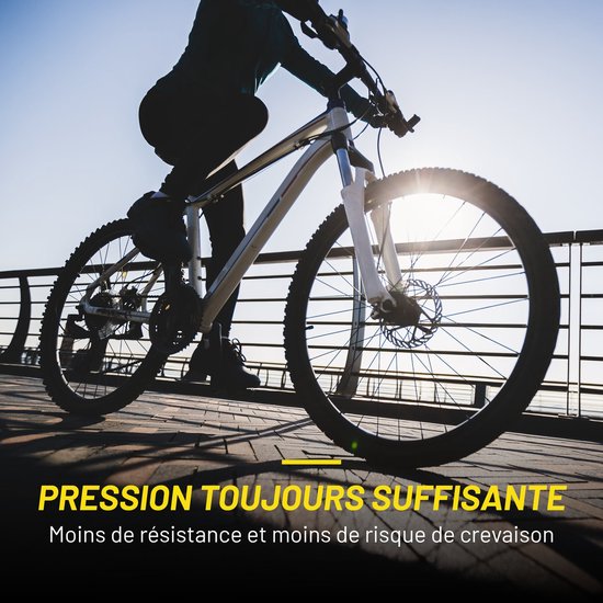 Fietser op een fiets met een grote voorband in de zon. Tekst: 'Pression Toujours Suffisante'.