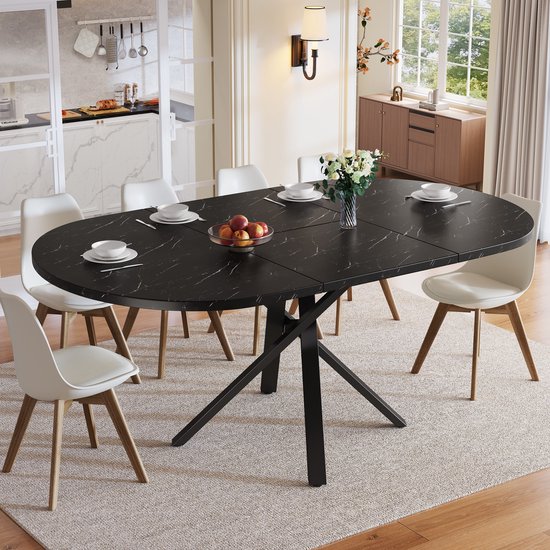 Zwarte, ovale eettafel met marmerlook, acht witte stoelen en zwarte X-poten.