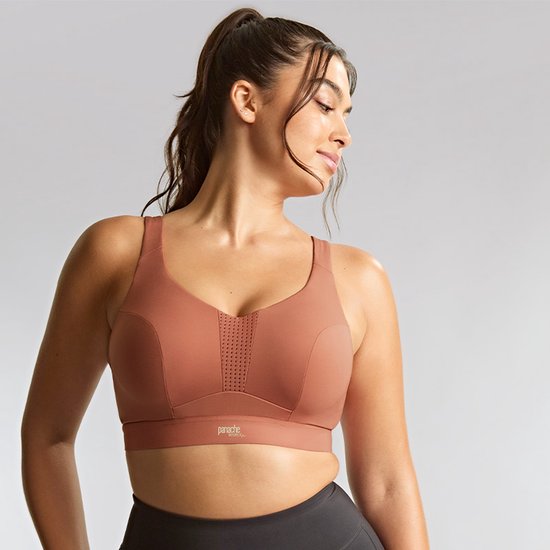 Model draagt een Panache sportbeha in Sienna Rose, met perforaties op de borst.