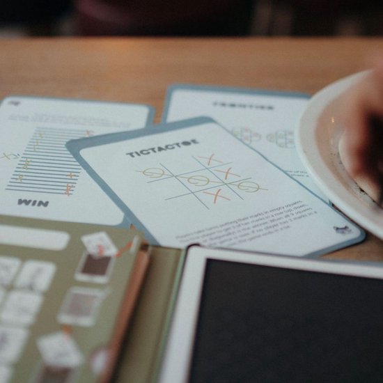 Kaarten met TicTacToe en 'WIN' instructies op een tafel.