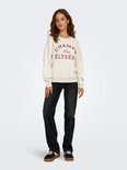 Model draagt een lichtgrijze sweater met 'CHAMPS Paris ÉLYSÉES' opdruk, gecombineerd met een zwarte jeans.
