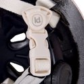 Sluiting van de kinderhelm met 'ld.' logo en witte bandjes.