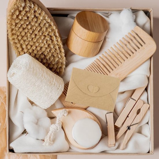 Een bruine kraftenvelop met hartsluiting in een geschenkdoos met verzorgingsproducten en een houten kam.