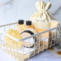Een witte mand gevuld met 'Spa Luxetique Vanilla' badproducten, waaronder een tas, badspons en bodylotion.