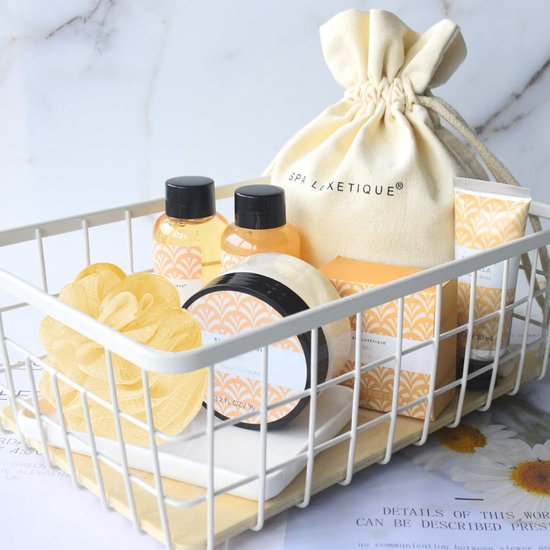 Een witte mand gevuld met 'Spa Luxetique Vanilla' badproducten, waaronder een tas, badspons en bodylotion.