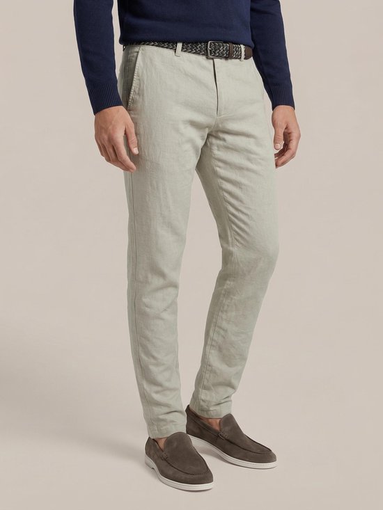 Man met donkerblauw trui, beige broek, riem en bruine instappers.