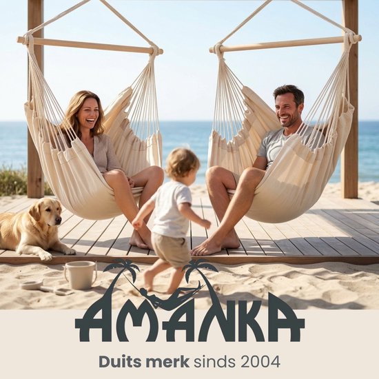 Twee crèmekleurige hangstoelen op het strand met een gezin en een hond.