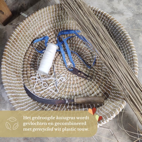 Gevlochten mand van kaisagras met blauw meetlint, witte draad, tang en mes. Tekst: 'Het gedroogde kaisagras wordt gevlochten en gecombineerd met gerecycled wit plastic touw.'