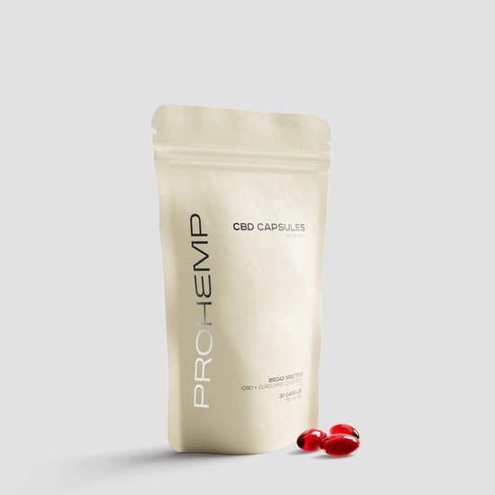 Crèmekleurige pouch van ProHemp met 'CBD Capsules Recovery' erop. Drie rode capsules liggen ervoor.