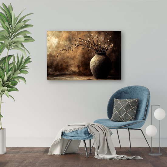 Canvasafdruk met een donkere, aardse vaas gevuld met gedroogde bloemen. Achtergrond is een bruin en goudkleurig abstract schilderij. Hangt boven een blauwe stoel.