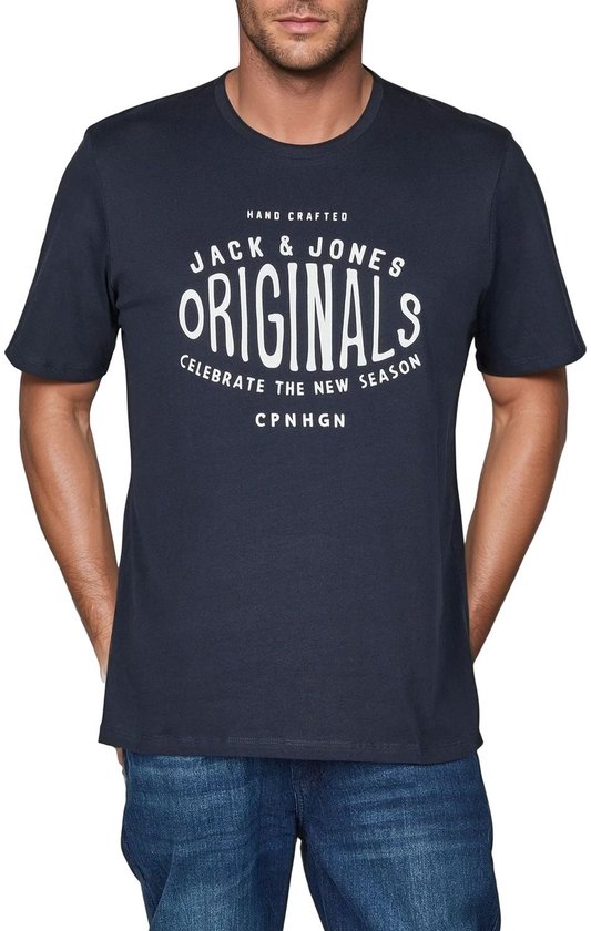 Man met donkerblauw T-shirt met opdruk "Jack & Jones Originals Celebrate The New Season CPN HGN" en spijkerbroek.