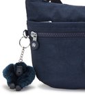 Detail van een donkerblauwe Kipling schoudertas met een harige aap sleutelhanger.
