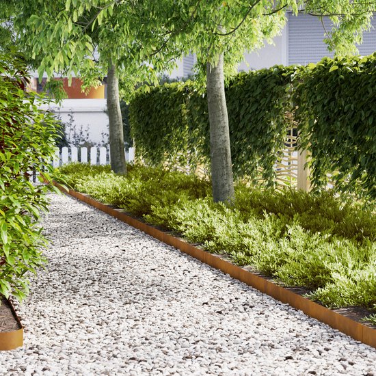 Een tuinpad van wit grind, begrensd door roestbruine metalen borderranden en groen struikgewas.