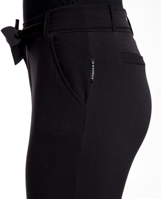 Detail van de tailleband met strikceintuur van een zwarte broek. Het merk 'JE M'APPELLE' is zichtbaar.