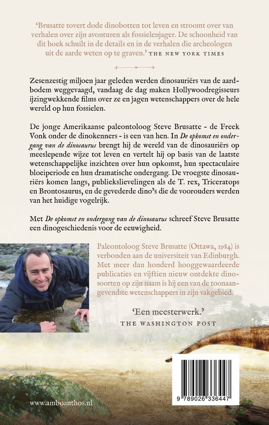 Man met donkere jas kijkt glimlachend naar de camera, met een rotsachtige ondergrond.
