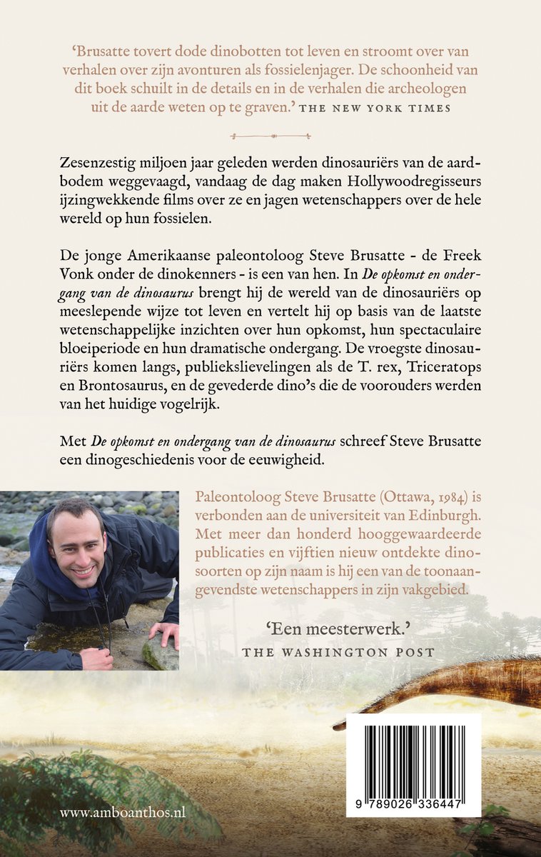 Man met donkere jas kijkt glimlachend naar de camera, met een rotsachtige ondergrond.