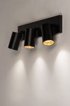 Plafonnier noir avec trois spots à l'intérieur doré, montés sur une barre noire.