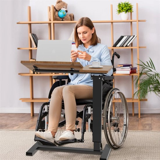 Vrouw in rolstoel gebruikt een houten laptoptafel met verstelbaar blad.