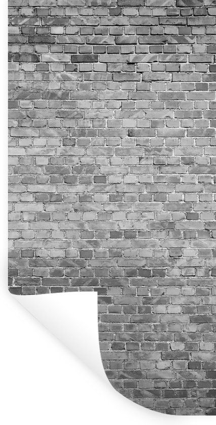 Un autocollant mural brique grise avec un coin enroulé, sur fond blanc.
