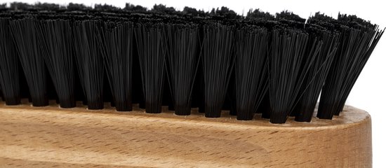 Gros plan sur des poils de textile noirs sur un manche en bois.