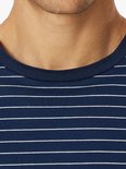 Close-up van marineblauw T-shirt met dunne horizontale witte strepen bij de hals.