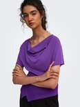 Close-up van een model met krullend haar in een paarse ONLY top met gedrapeerde halslijn en korte mouwen.