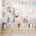 Kinderkamer met een witte modulaire kast, gevuld met speelgoed en boeken. Sommige vakken hebben een patroon van verticale ribbels.