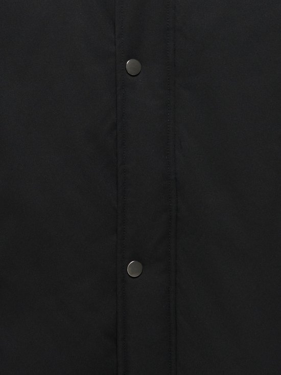 Detailopname van de zwarte stof van de parka met een drukknoopsluiting.