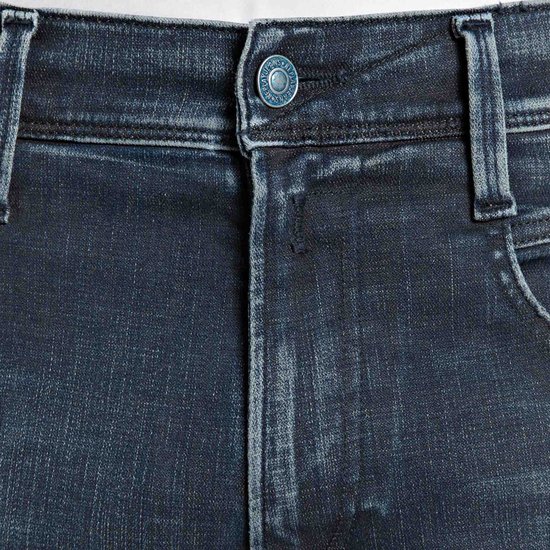 Close-up van de tailleband en knoopsluiting van een donkerblauwe Replay jeans met ingegraveerd merklogo.