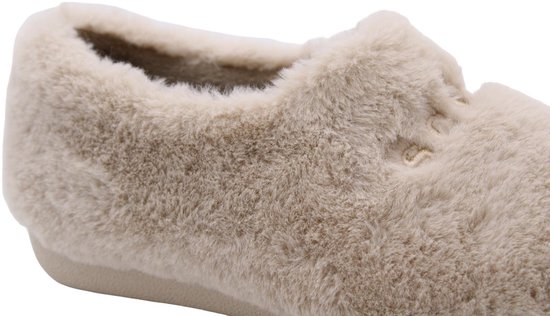 Detail van een zachte, beige faux-fur pantoffel met een dikke, harige textuur.