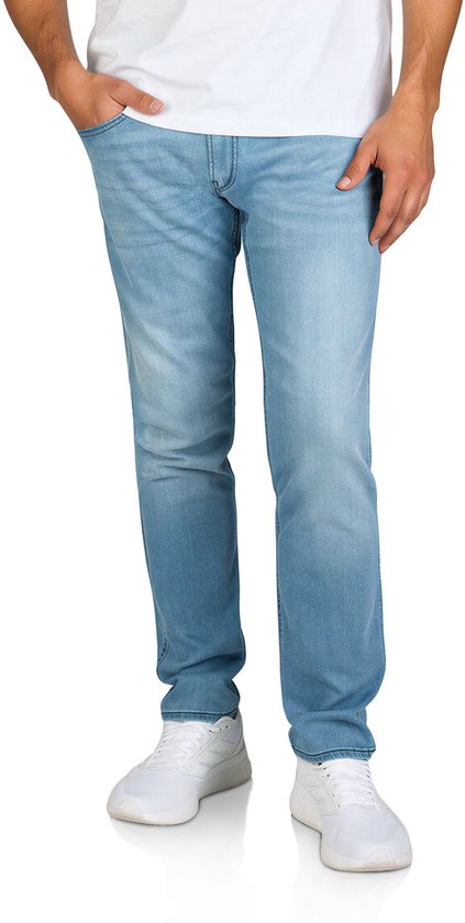 Voorkant van een man in lichtblauwe Replay Anbass slim fit jeans gecombineerd met een wit T-shirt en witte sneakers.