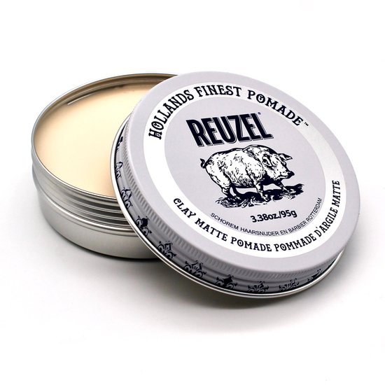 Open blikje Reuzel Clay Matte Pomade met deksel ernaast, op een witte achtergrond.