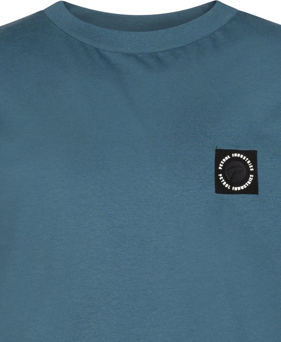 Petrol Industries T-shirt in blauw met een zwarte, ronde merkpatch op de borst met witte tekst.