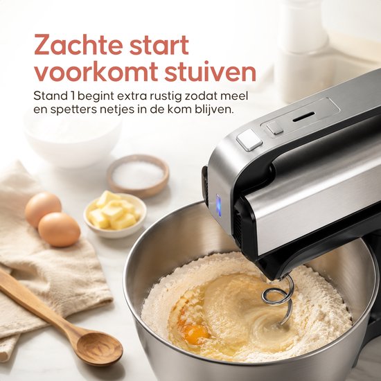 Close-up van de zilveren Broba handmixer met deeghaak in een kom met bloem en eieren.