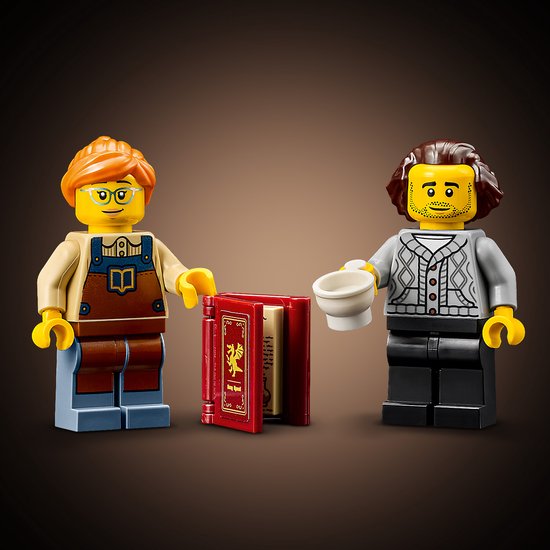 Twee LEGO minifiguren, één met bril en overall, de ander met vest, bij een opengeslagen rood boek.