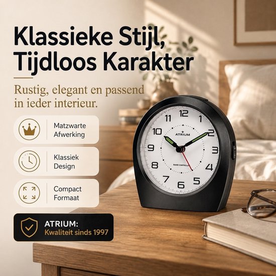 Klassieke, matzwarte radiografische wekker met witte wijzerplaat, groene secondewijzer. Iconen tonen matzwarte afwerking, klassiek design en compact formaat.