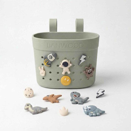 Lichtgroen Banwood mandje met gaatjes, versierd met dinosaurussen en ruimte-accessoires.