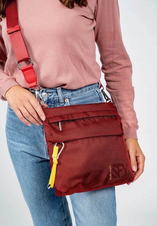 Rode damestas gedragen door een model, met rode schouderband en geel sleutelkoordje.