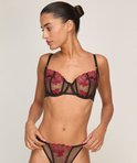 Zwarte beugelbeha met doorschijnende cups, versierd met roze bloemenpatroon en zwarte bandjes.