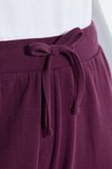 Donkerpaarse sweatculotte met gestrikte tunnelkoord in de taille.