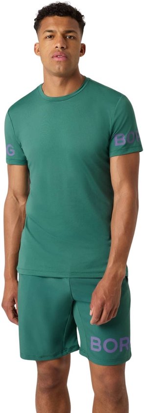 Man in een mallardgroen sportshirt met logo op de mouwen en bijpassende mallardgroene sportshort.