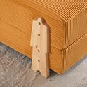 Gedetailleerde close-up van de houten poten van een oranje corduroy slaapfauteuil.