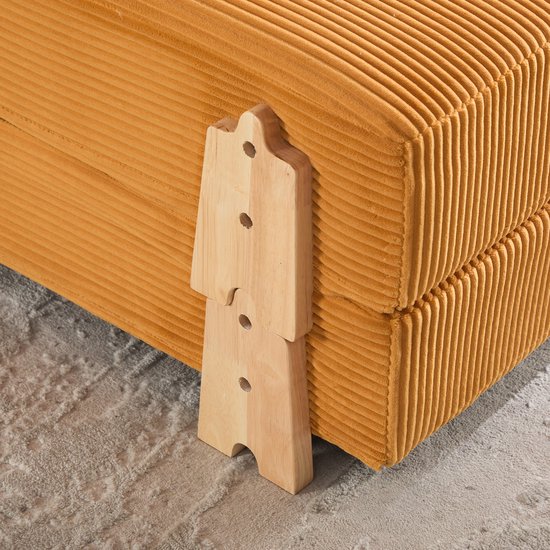 Gedetailleerde close-up van de houten poten van een oranje corduroy slaapfauteuil.