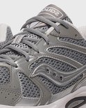 Close-up van de bovenkant van een grijze Saucony Ride Millennium sneaker met veters en Saucony logo.